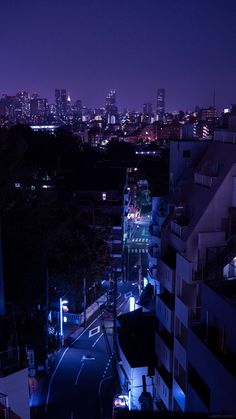 the city skyline is lit up at night, with buildings and street lights in the foreground