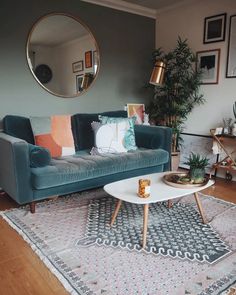 a living room filled with furniture and a large round mirror on the wall above it