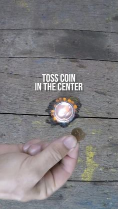 a person holding a lit candle in their left hand with the words toss coin in the center