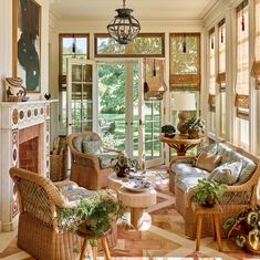 a living room with wicker furniture and large windows that look out onto the yard