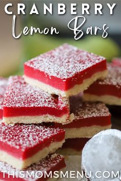 cranberry lemon bars are stacked on top of each other with powdered sugar