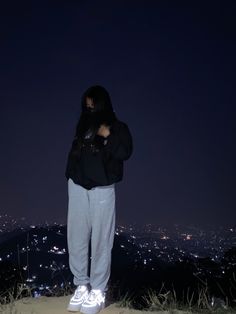 a person standing on top of a hill at night