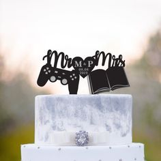 a close up of a wedding cake with a book and video game controller on top