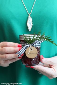 a woman holding a jar filled with jam