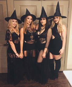 four women dressed in witches costumes posing for a photo