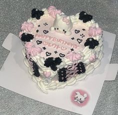 a heart shaped birthday cake with pink and black decorations