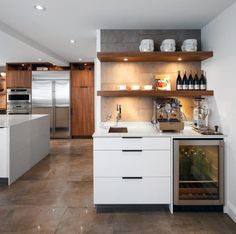 a kitchen with an oven, refrigerator and wine bottles on the shelves in front of it