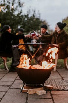 people sitting around a fire pit on the ground