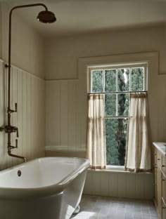 a bath tub sitting next to a window in a bathroom