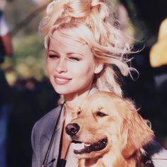 a woman with blonde hair holding a dog