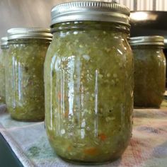 three jars filled with green stuff sitting on top of a table