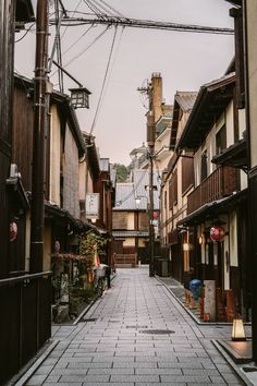 an alley way with buildings and people walking on the sidewalk in front of each other