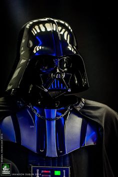 a darth vader helmet on display in a dark room with blue light from the side