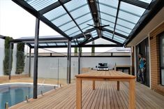 a wooden table sitting on top of a hard wood floor next to a swimming pool