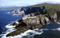 an aerial view of the ocean and rocky coastline