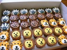 a box filled with lots of cupcakes covered in frosting and decorated like animals