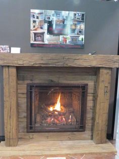 a fire place in a room with pictures on the wall and tile flooring around it