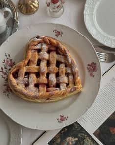 a heart shaped waffle sitting on top of a plate next to an open book