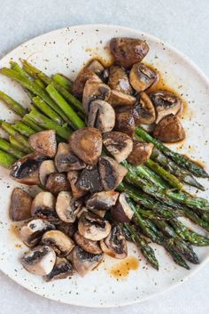 asparagus and mushrooms on a white plate with balsamic roasted asparagus