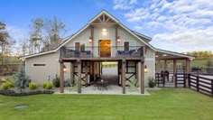 a large white barn with an open porch and covered patio area in the front yard