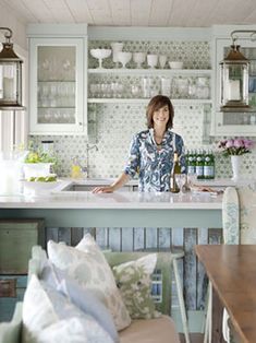 a woman standing at the counter in a kitchen