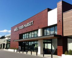 the outside of a well - stocked market store on a sunny day with blue skies