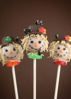 three scarecrow lollipops on sticks with faces painted to look like witches