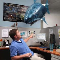 two children are playing with an inflatable shark and clown fish at the living room