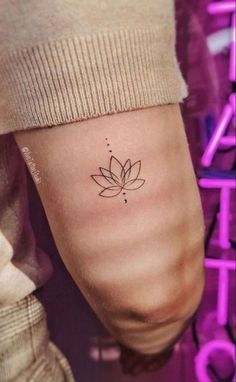 a woman's foot with a small lotus tattoo on the left side of her leg