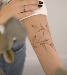 a woman's arm with a flower tattoo on the left side of her arm