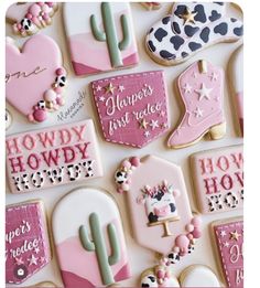 decorated cookies with pink and white frosting are arranged on a table top in the shape of cactuses