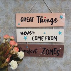 two wooden signs that say great things, never come from comfort zones and some flowers