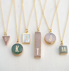 four different necklaces with letters on them