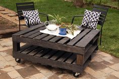 an outdoor table made out of pallet wood with two chairs and a potted plant on top