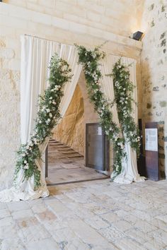 an outdoor ceremony with white flowers and greenery