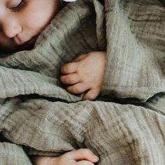 a small child wrapped in a blanket sleeping