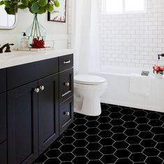 a bathroom with black and white hexagonal tiles on the floor