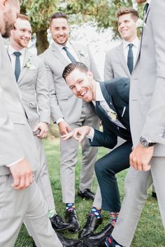 a group of men standing next to each other in suits and ties with their feet on the ground