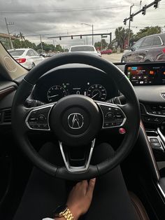 the interior of a car with steering wheel, dashboard and dash lights in front of other cars