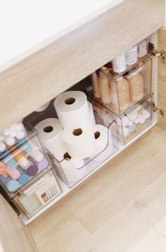 an organized bathroom drawer with toilet paper and other items in the drawers, including rolls of toilet paper