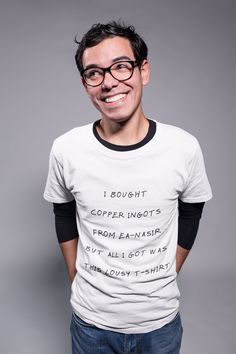 a man wearing glasses and a t - shirt with writing on it