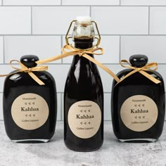 three black bottles with labels on them tied together