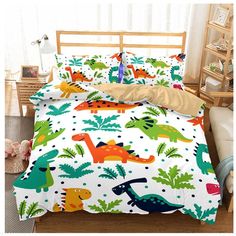 a bed room with a neatly made bed and dinosaur themed comforter sets on it