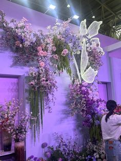 a woman standing in front of a display of flowers