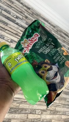 a hand holding up a green plastic bag with an animal print on the front and side