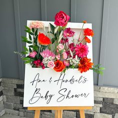 a baby shower sign with flowers on it