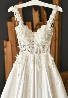 a white wedding dress hanging on a hanger