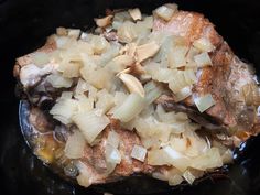 onions and meat cooking in a slow cooker