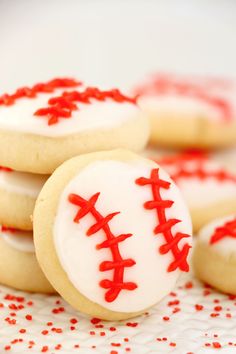 cookies decorated with white frosting and red sprinkles are on a plate