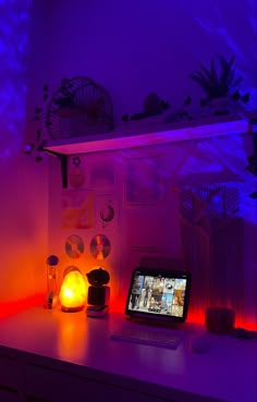 a laptop computer sitting on top of a desk next to a lamp and other items